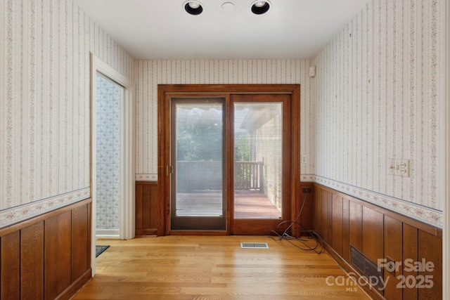 entryway featuring wood walls and light wood-type flooring