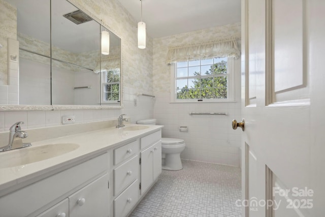 bathroom with tile patterned flooring, plenty of natural light, tile walls, and vanity