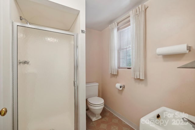 bathroom featuring tile patterned flooring, toilet, and an enclosed shower