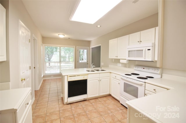 kitchen with white cabinets, white appliances, sink, kitchen peninsula, and light tile patterned flooring