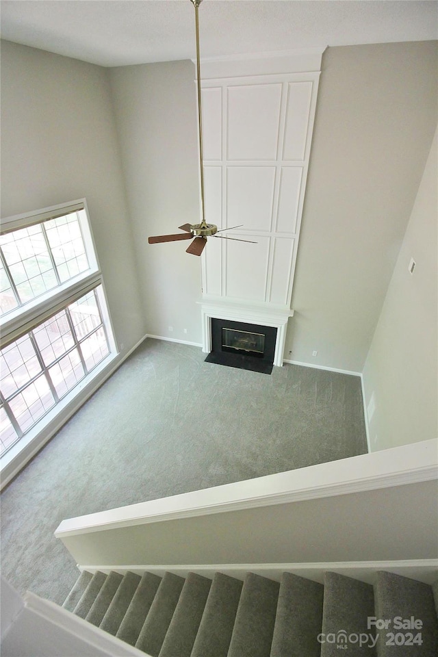 interior space with ceiling fan and carpet floors