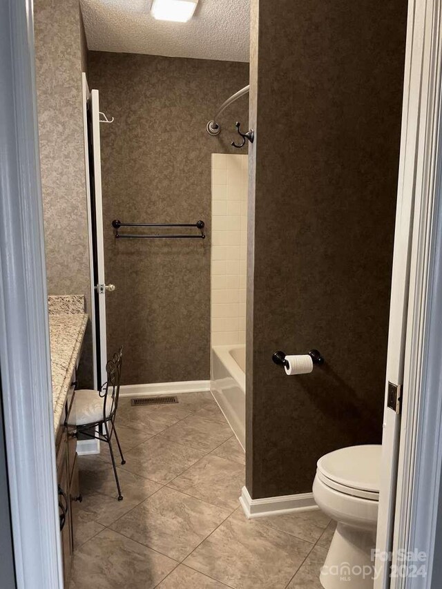 full bathroom with tile patterned flooring, toilet, shower / bath combination, vanity, and a textured ceiling