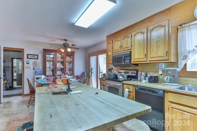 kitchen with a textured ceiling, black appliances, ceiling fan, and tasteful backsplash