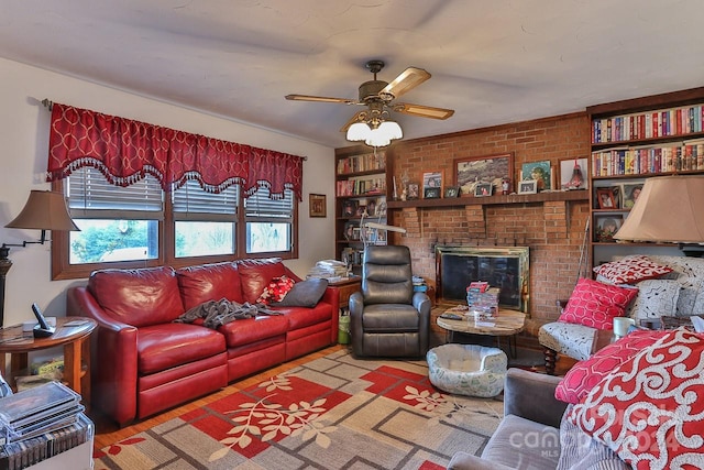 living room featuring light wood-type flooring, a brick fireplace, brick wall, and ceiling fan