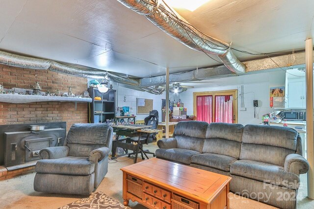 living room with ceiling fan and a wood stove