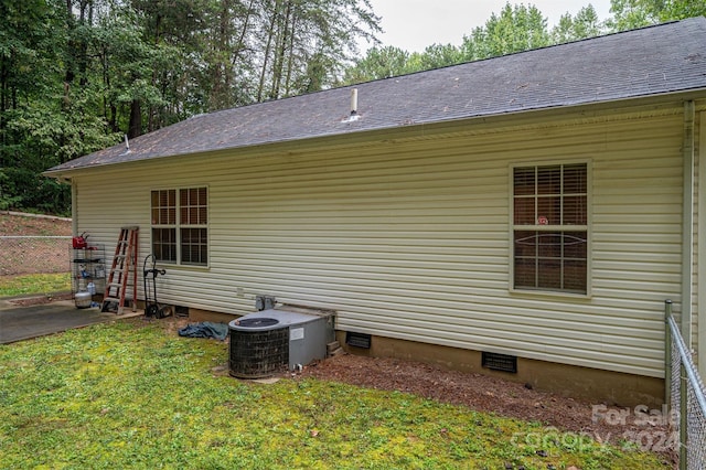 view of home's exterior with a lawn and central AC unit