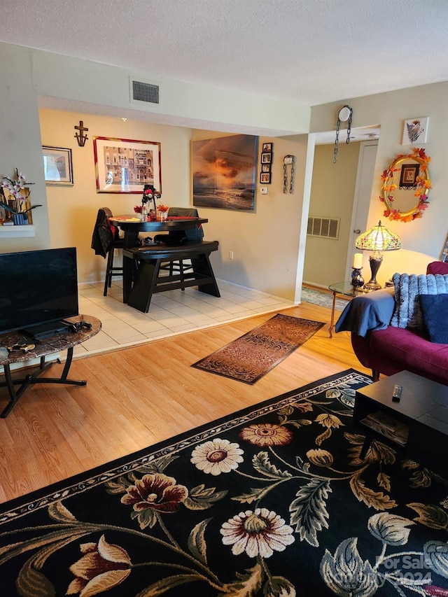 living room with light hardwood / wood-style flooring and a textured ceiling