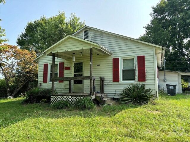 bungalow-style home featuring covered porch and a front lawn