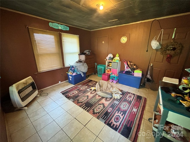 rec room featuring crown molding, light tile patterned flooring, and heating unit