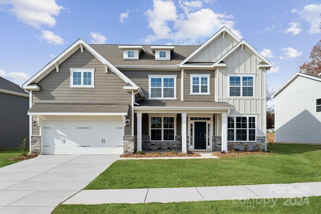 craftsman inspired home featuring a porch, a garage, and a front yard