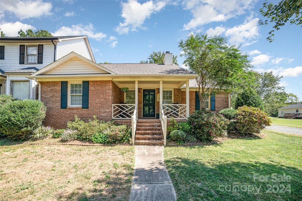 view of front of property with covered porch and a front lawn