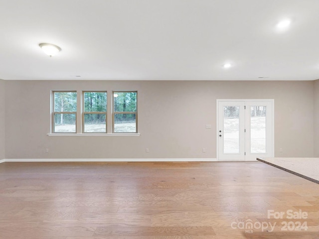 empty room with plenty of natural light and light hardwood / wood-style floors