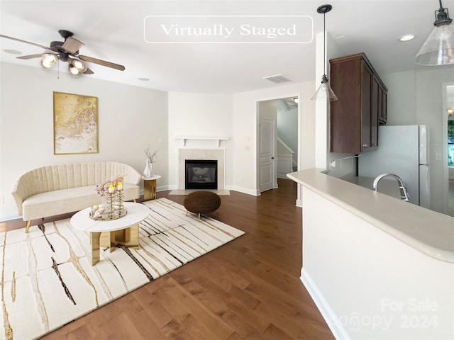 living room featuring ceiling fan, dark hardwood / wood-style floors, and sink