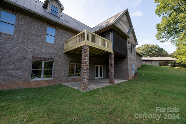 rear view of property featuring a lawn and a patio