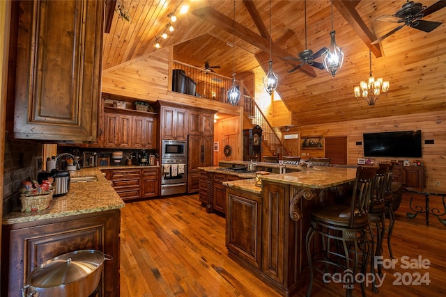 kitchen featuring high vaulted ceiling, wood walls, pendant lighting, wooden ceiling, and beam ceiling