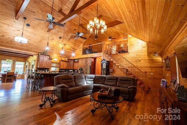 living room with high vaulted ceiling, wooden walls, and hardwood / wood-style flooring