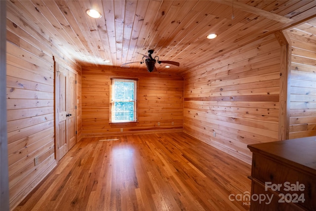 additional living space featuring wooden ceiling, light hardwood / wood-style floors, wooden walls, and ceiling fan