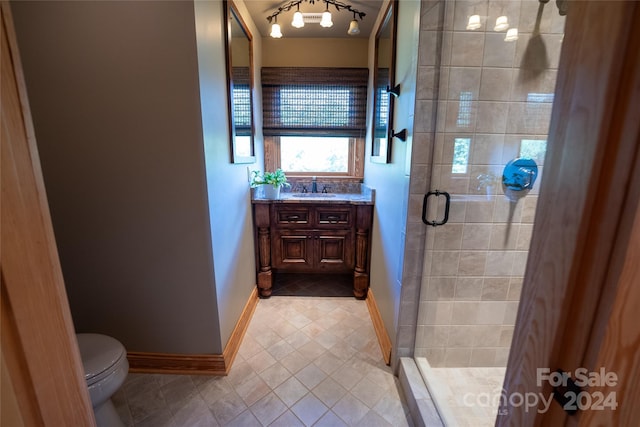 bathroom featuring tile patterned floors, walk in shower, vanity, and toilet