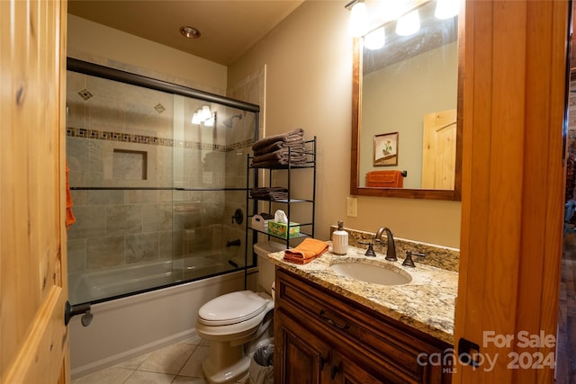 full bathroom with enclosed tub / shower combo, vanity, tile patterned flooring, and toilet