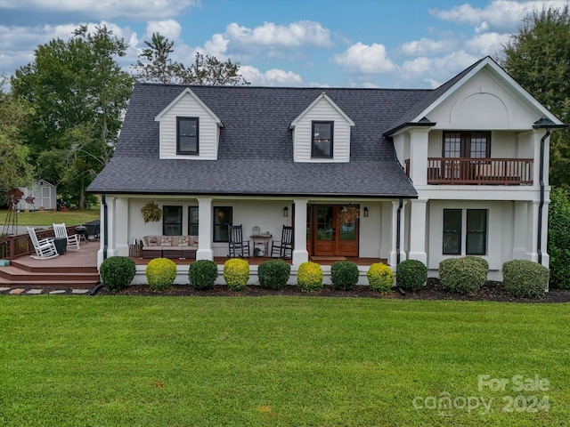 view of front of house featuring a front yard, a porch, and a shed