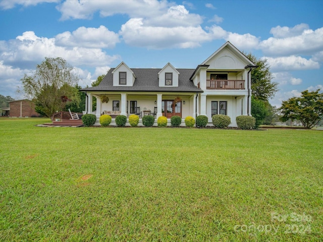 view of front of home featuring a balcony, a porch, and a front yard