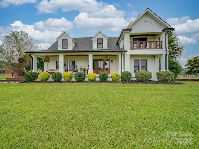 view of front of house with a balcony, covered porch, and a front yard