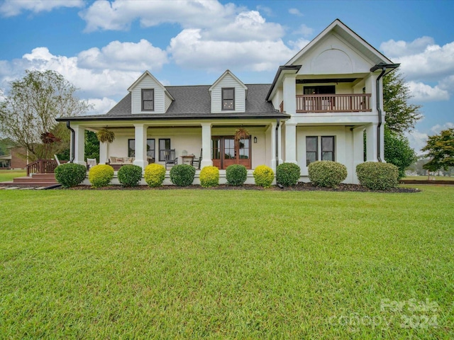 view of front of property featuring a porch, a shingled roof, stucco siding, and a front yard