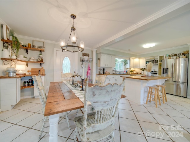dining space with crown molding, a notable chandelier, and light tile patterned flooring