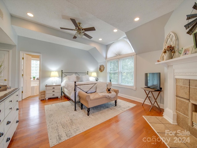 bedroom featuring ceiling fan, light wood-type flooring, vaulted ceiling, and multiple windows