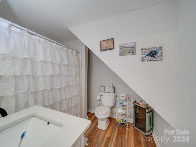 full bath with vanity, heating unit, wood finished floors, curtained shower, and toilet