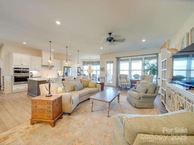 living room featuring ceiling fan and light hardwood / wood-style flooring