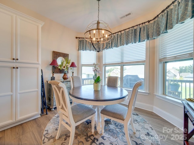 dining area featuring a notable chandelier and light hardwood / wood-style floors