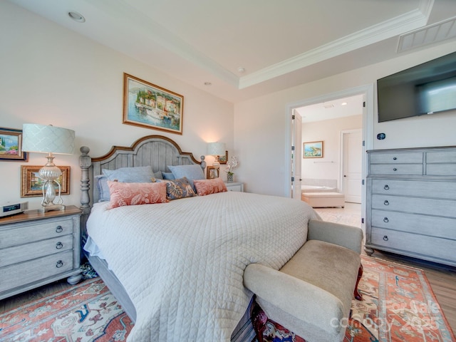 bedroom featuring hardwood / wood-style flooring, ensuite bathroom, and ornamental molding