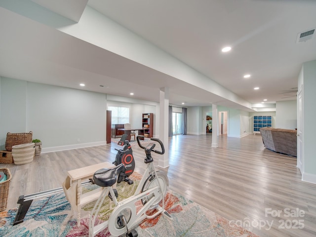 exercise room with light hardwood / wood-style flooring