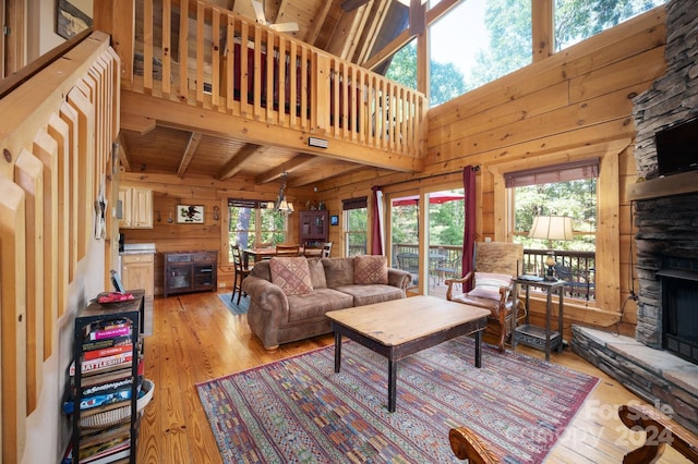 living room featuring a fireplace, wood ceiling, light hardwood / wood-style floors, wood walls, and ceiling fan