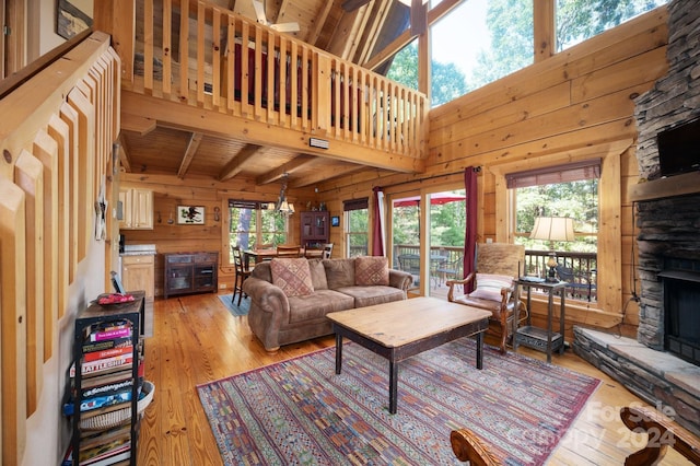 117 Laurel Lakes Pkwy, Lake Lure, NC 28746 - living room featuring light wood-style floors, a fireplace, plenty of natural light, beam ceiling, and wood walls