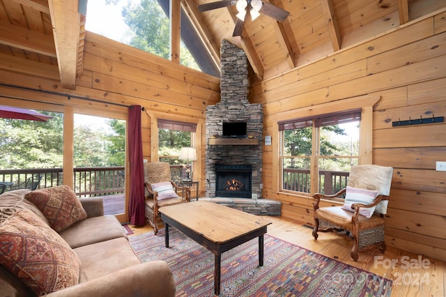 117 Laurel Lakes Pkwy, Lake Lure, NC 28746 - living area featuring wooden ceiling, beamed ceiling, wood finished floors, a ceiling fan, and a stone fireplace