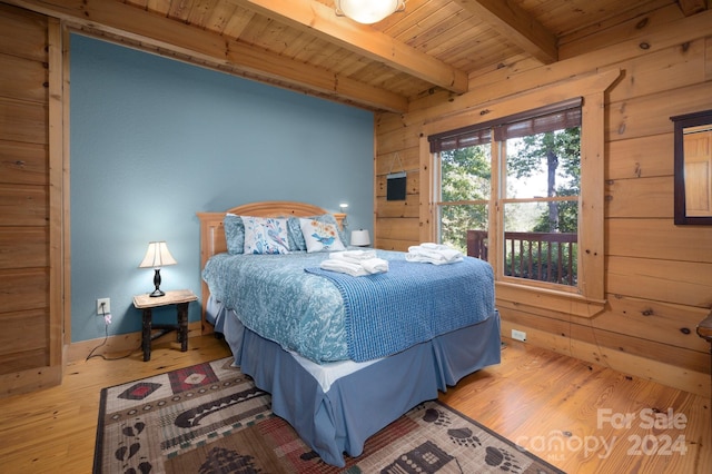 bedroom with wooden ceiling, wood-type flooring, beam ceiling, and wooden walls