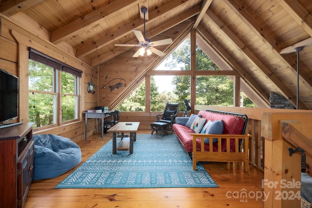 living room featuring wooden walls, ceiling fan, vaulted ceiling with beams, wood ceiling, and light hardwood / wood-style floors