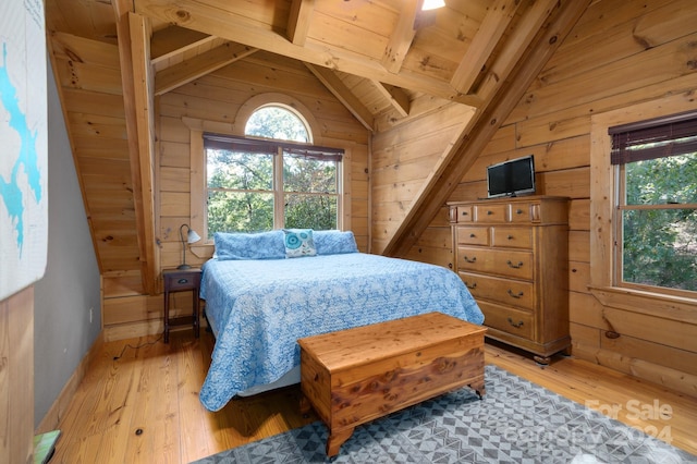 bedroom with light wood-type flooring, lofted ceiling with beams, wooden walls, and wooden ceiling