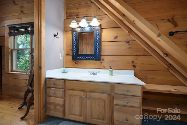 bathroom featuring wooden walls, vanity, wood-type flooring, wooden ceiling, and lofted ceiling