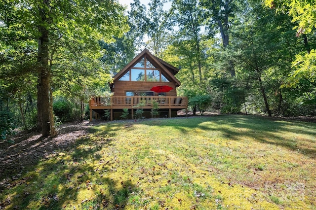 rear view of house featuring a lawn and a deck