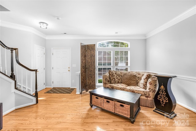 living room with crown molding and light hardwood / wood-style floors