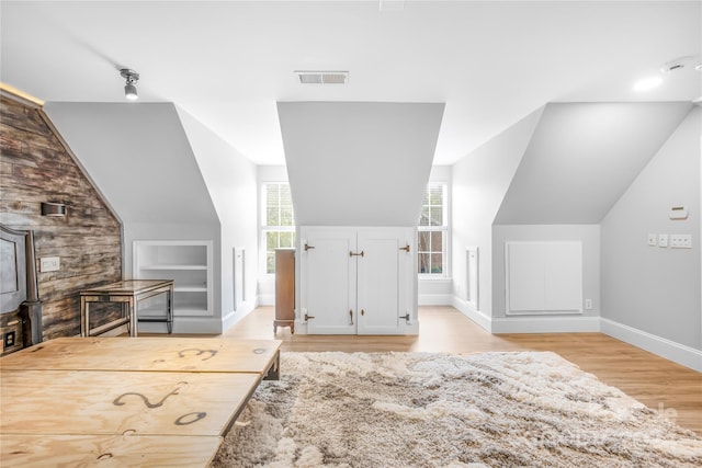 bonus room with lofted ceiling and light hardwood / wood-style floors