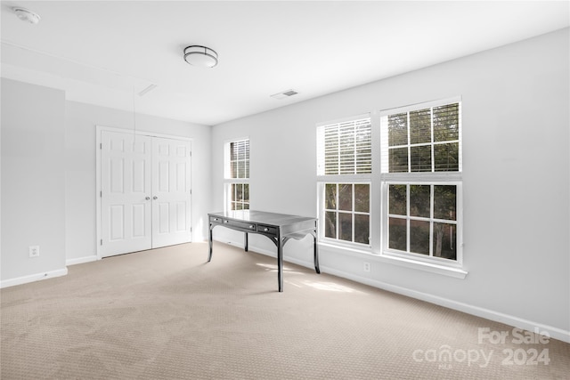 unfurnished office featuring attic access, visible vents, carpet flooring, and baseboards