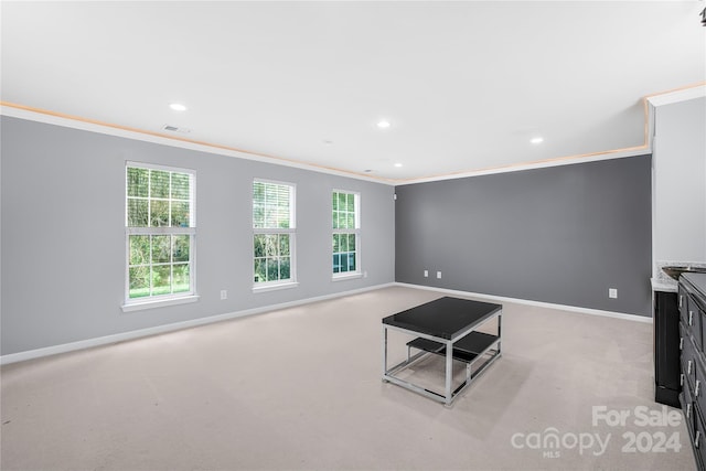 unfurnished living room featuring light carpet and ornamental molding