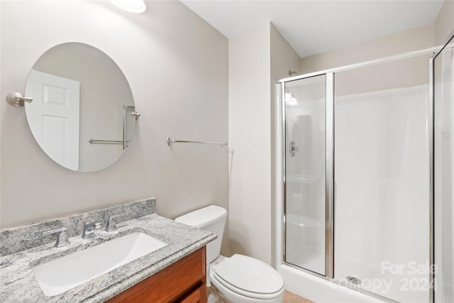 bathroom featuring walk in shower, vanity, and toilet