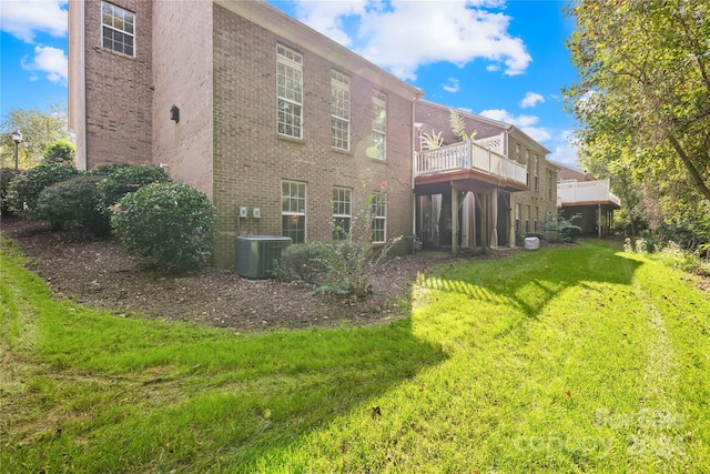 rear view of house featuring a lawn and a balcony