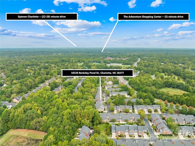 drone / aerial view with a wooded view and a residential view