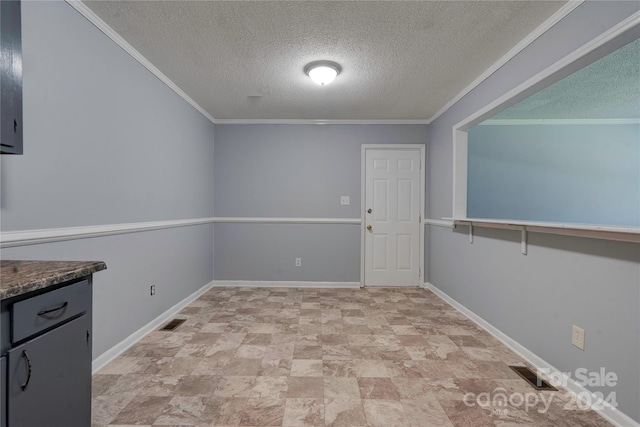 interior space with a textured ceiling and ornamental molding